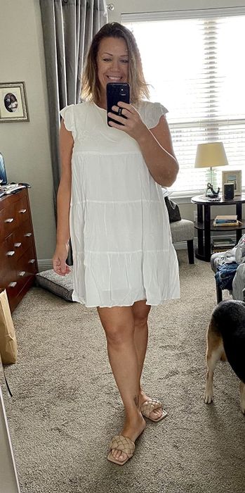 A reviewer dressed in a simple yet elegant white dress.