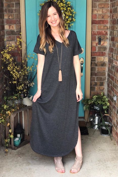 A reviewer styled in the gray maxi dress paired with a long necklace.