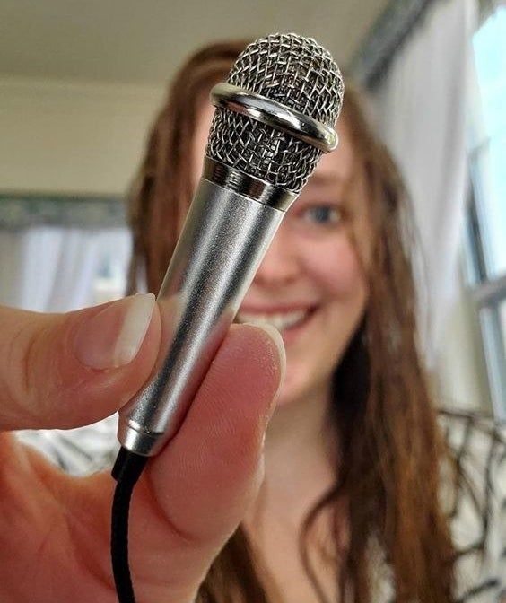 A reviewer shows off the mini microphone in hand.