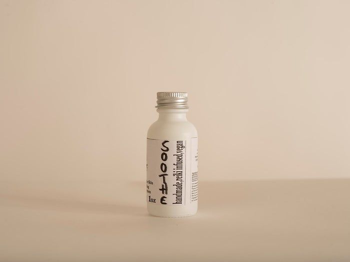 A sleek white bottle set against a soft, neutral background