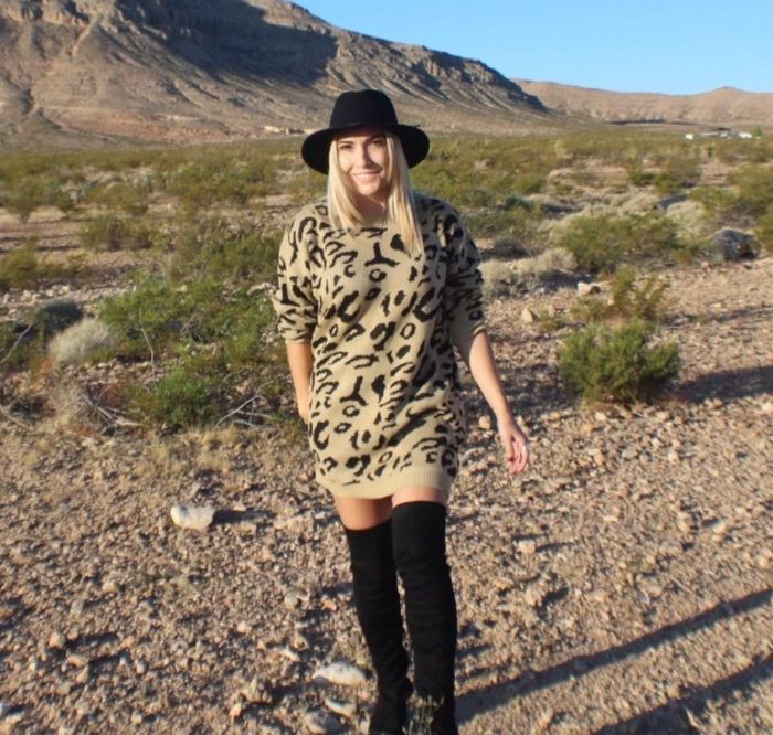 The reviewer is wearing the dress paired with black boots.