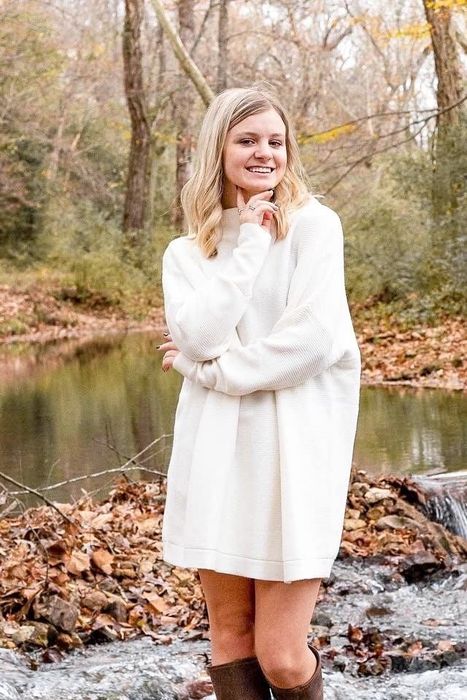 The reviewer is wearing a white dress.