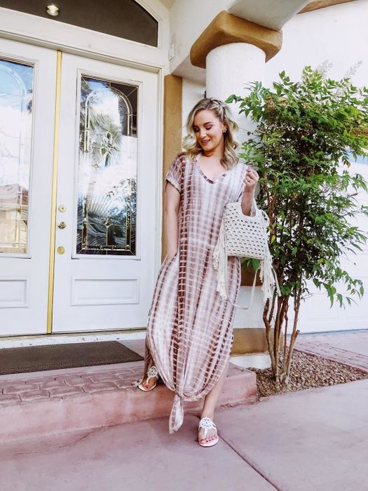 A reviewer in the white and mauve tie-dye dress