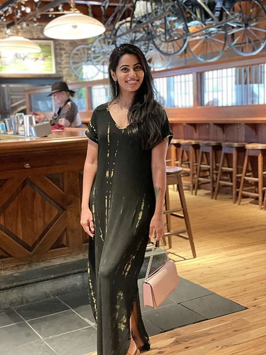 A reviewer wearing the black tie-dye dress
