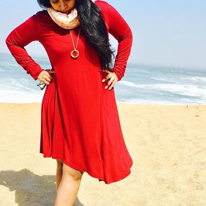 The reviewer is seen wearing a red dress.
