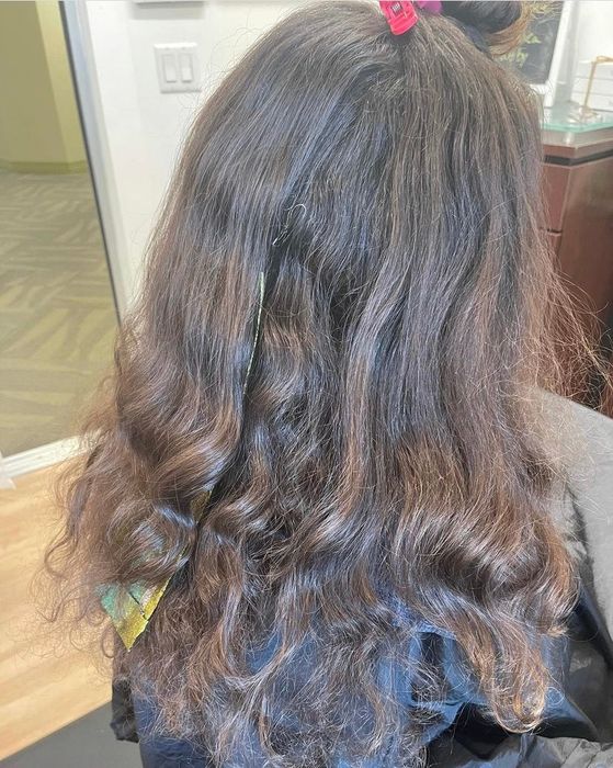 Reviewer's curly hair appearing dry and damaged.