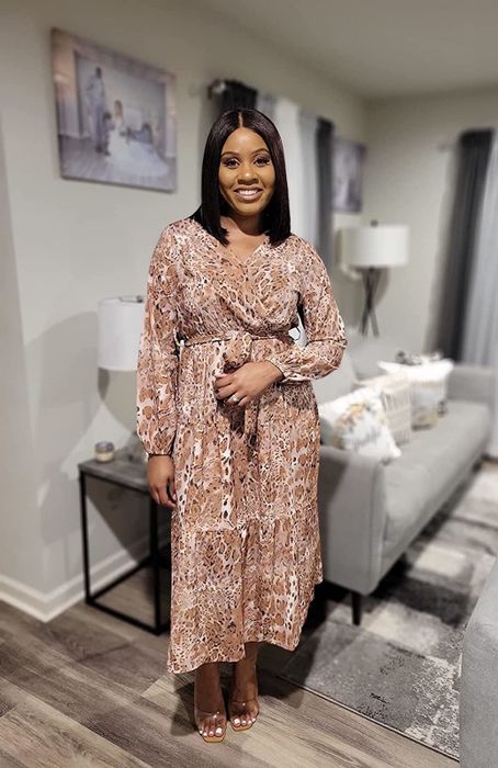 Reviewer showing off the dress in a chic brown print