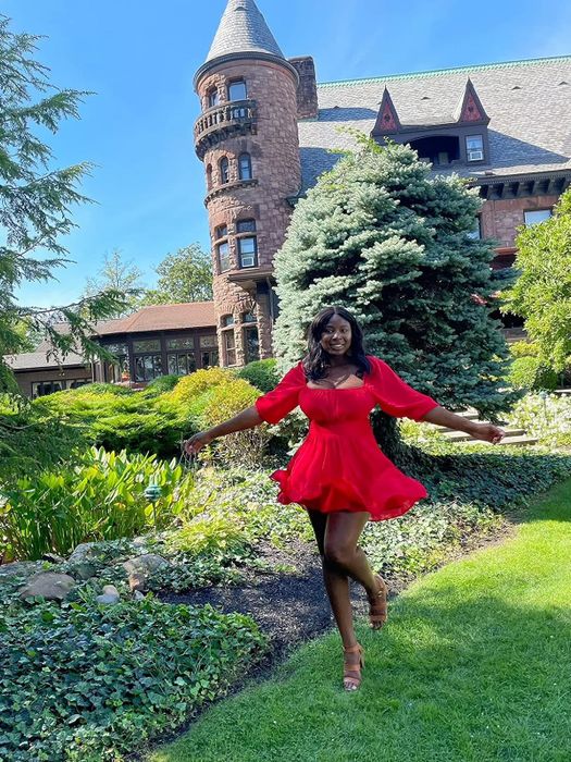 A reviewer in the red version of the dress