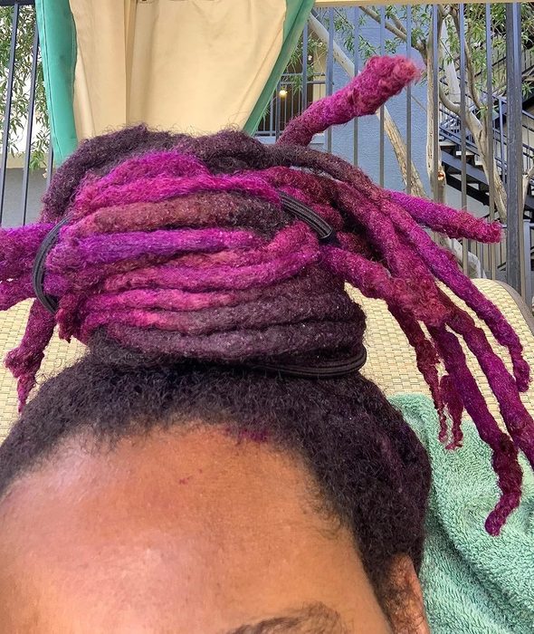 A reviewer with purple dreadlocks