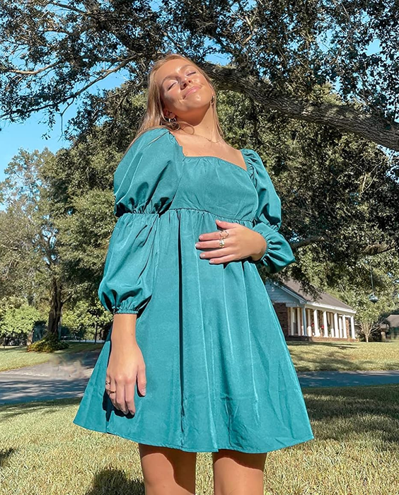 A reviewer in the turquoise dress, looking effortlessly chic
