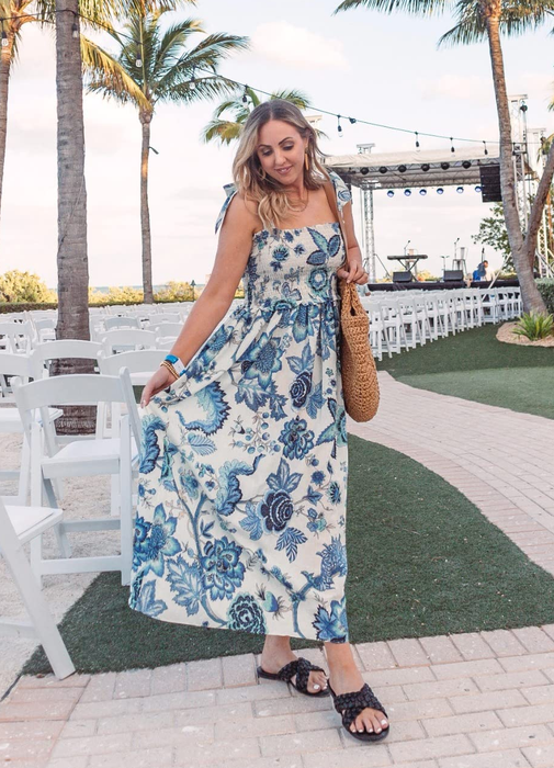 A reviewer in a blue floral dress
