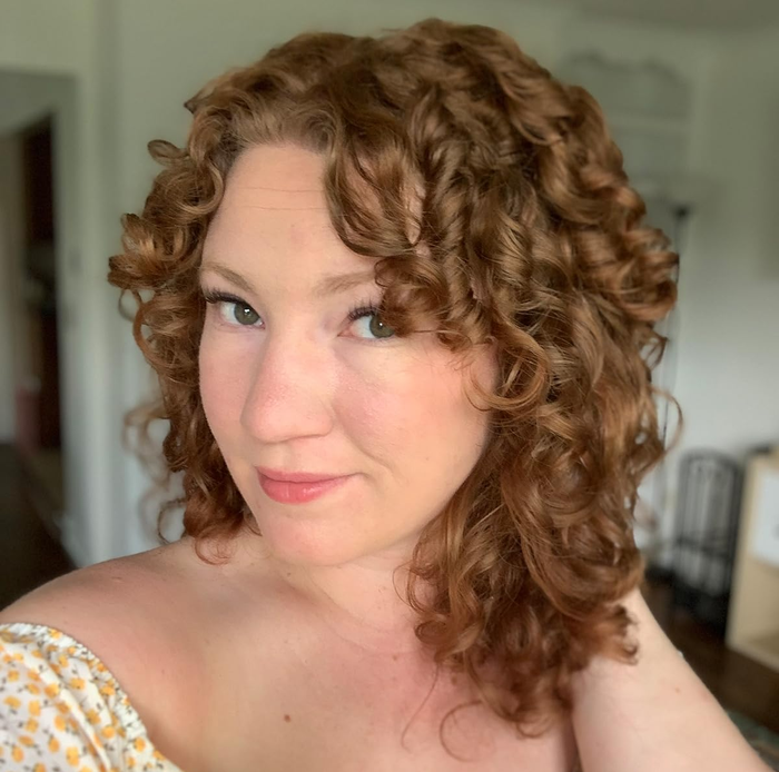 Reviewer with shoulder-length curls.