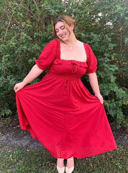 A reviewer donning the red version of the dress