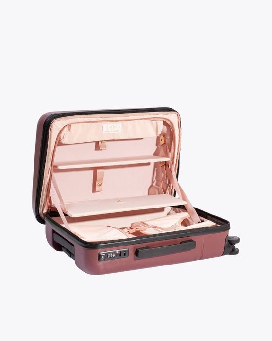 The suitcase in an elegant burgundy color, complemented by a vibrant pink interior.