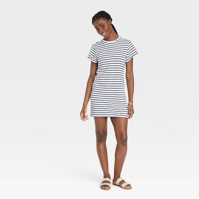 A model styled in a navy blue dress paired with sandals