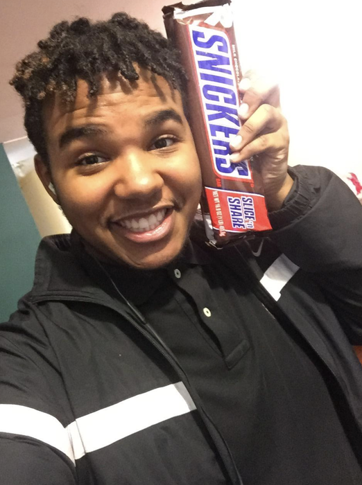 A reviewer holding up a giant Snickers bar.