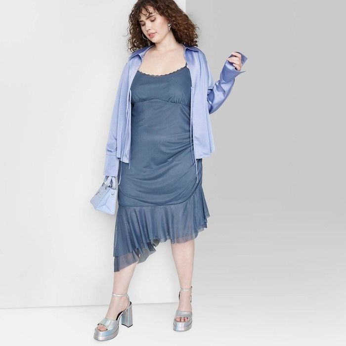 A model wearing the dress in navy blue, layered with a button-up shirt on top