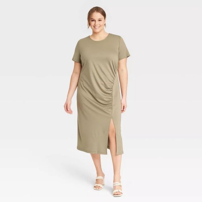 A model wearing the green short-sleeve ruched midi dress