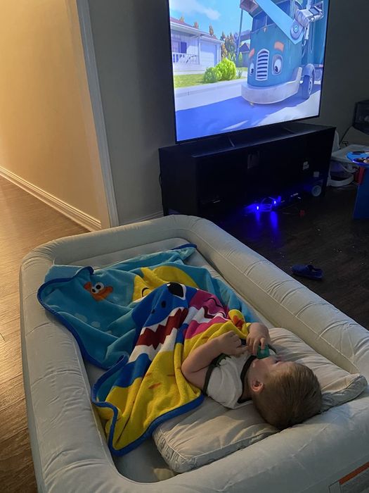 The child of the reviewer is peacefully sleeping on the gray mattress while enjoying a TV show.