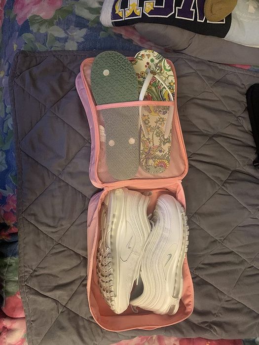 Another reviewer displays the shoe bag opened, with a pair of sneakers and two pairs of flip-flops neatly packed inside, showcasing its spaciousness.