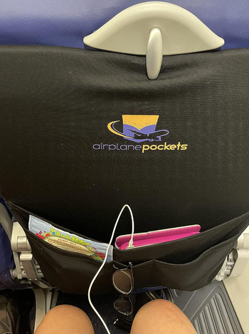 A reviewer shows a picture of a tray with a pocket that holds all their belongings.