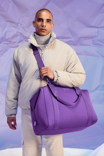 Model showcasing the purple version of the duffle bag