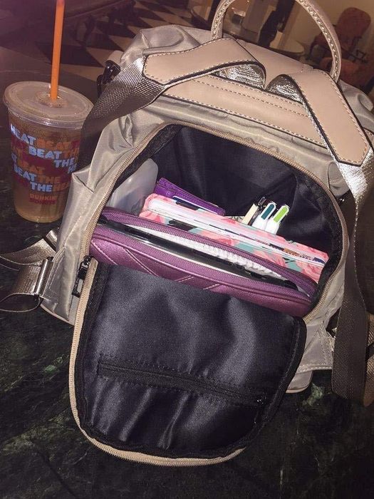 The reviewer demonstrates how the bag opens from the inside, revealing a spacious interior that can hold a variety of items.