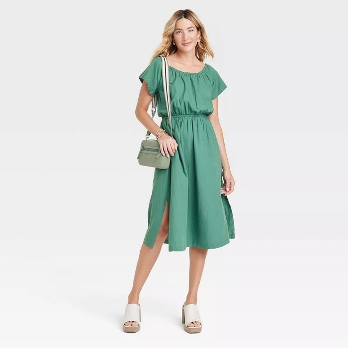 A model showcasing a green cotton-blend midi dress