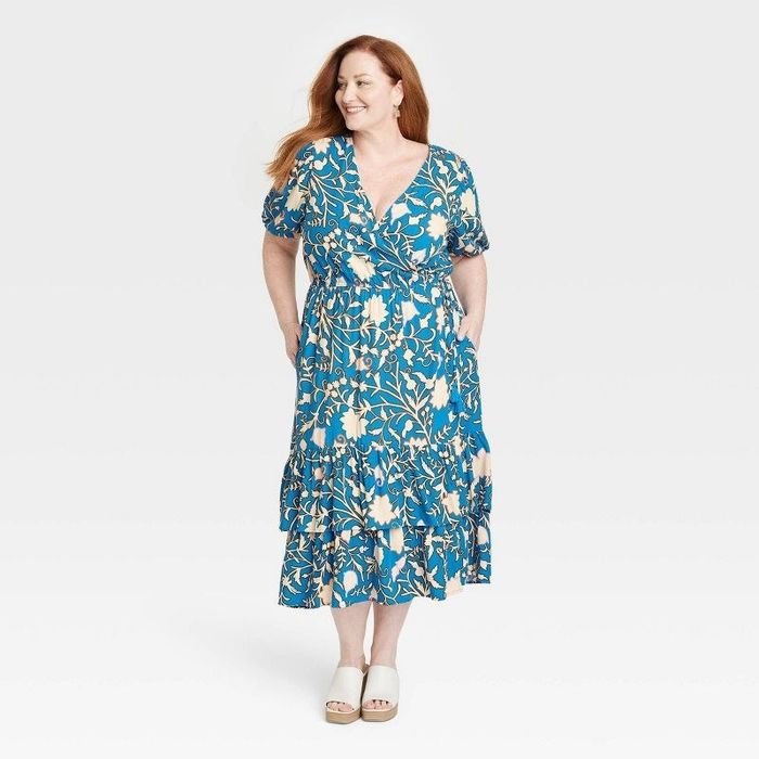A model wearing the dress in a blue floral print