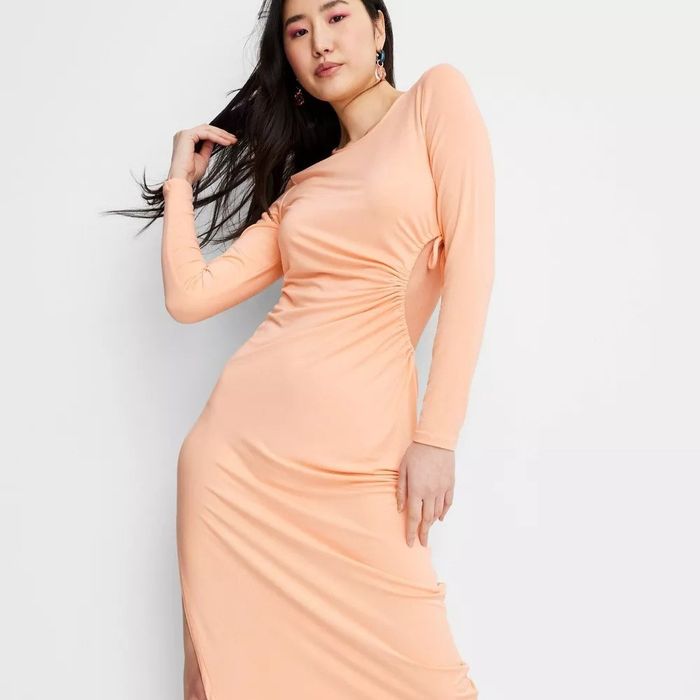 A model wearing a long-sleeve orange cutout dress