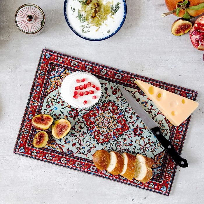The red and blue cutting board adorned with cheese and figs.