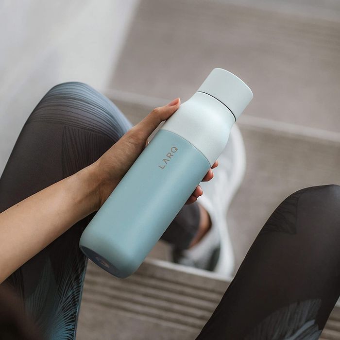 Model holding a blue water bottle.