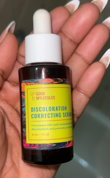 A reviewer holding the bottle of Good Molecules Discoloration Correcting Serum