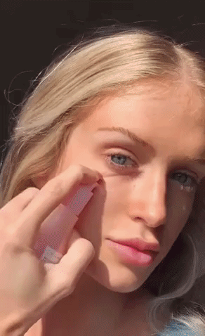 A gif of someone applying the dew drops and massaging them into their skin.