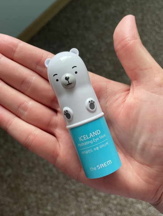 A reviewer holding a bear-shaped hydrating eye stick from The Saem, an Icelandic skincare brand