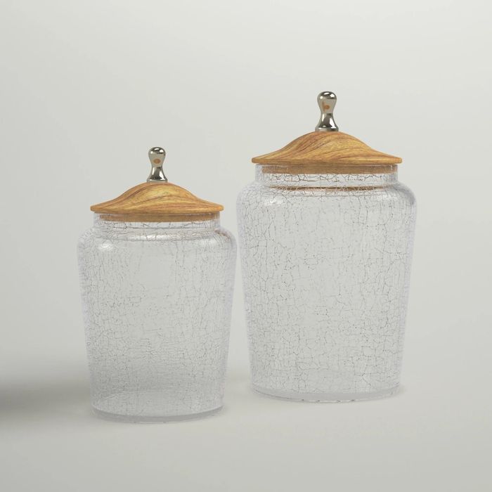 a collection of glass bathroom jars with wooden tops