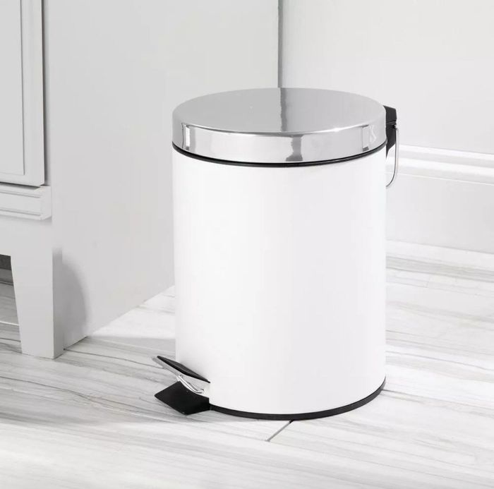 A white step trash can with a chrome lid.