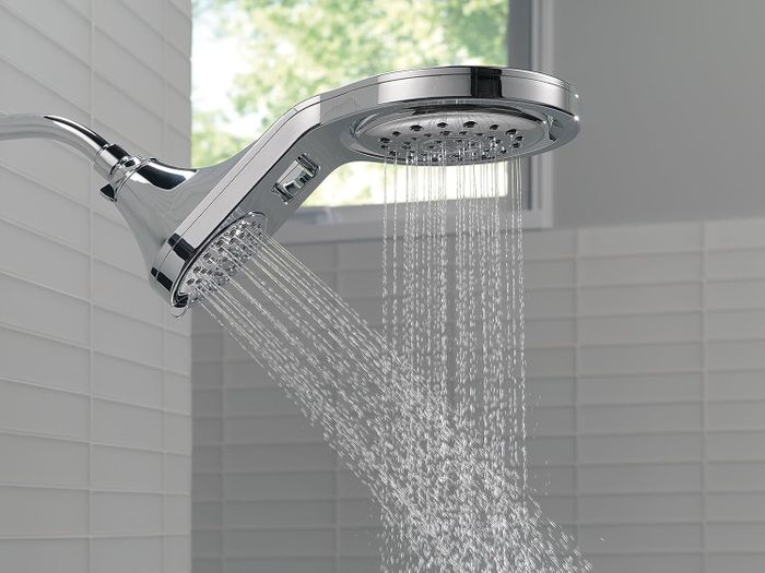 The water flows from both heads of the sleek stainless-steel showerhead, providing a refreshing experience.