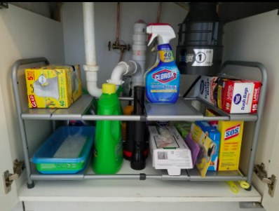 Reviewer's adjustable under-sink organizer with two shelves designed to fit around pipes, offering more storage space.