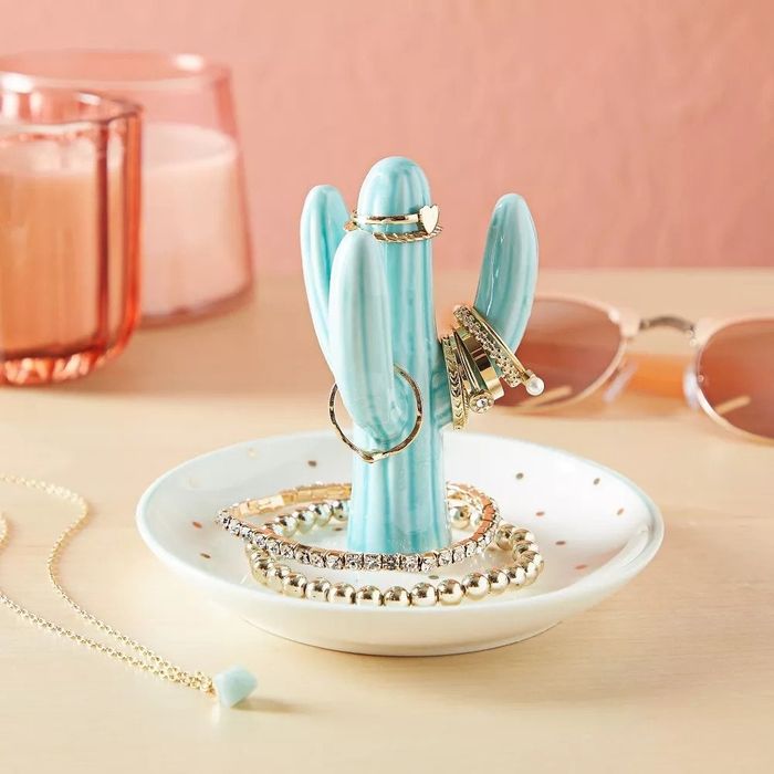 A cactus ring tray with various rings and jewelry displayed on it.