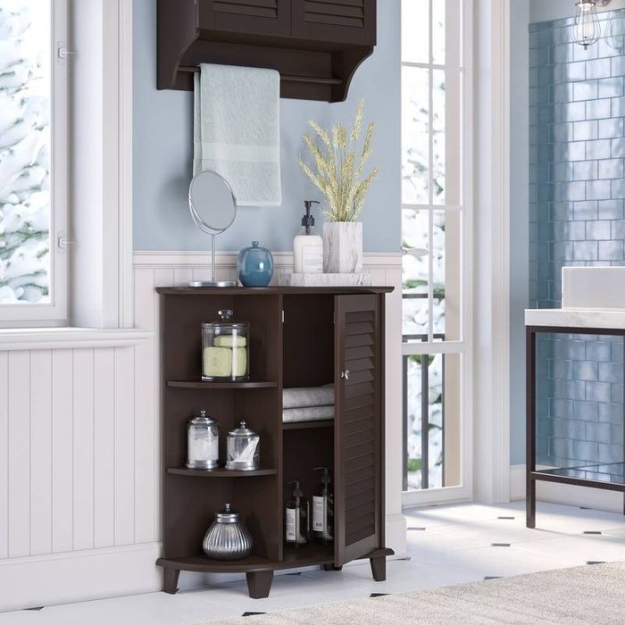 A brown floor cabinet with a shuttered door slightly open and three shelves on the side.