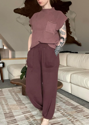 A person in a faded brick red top with maroon trousers