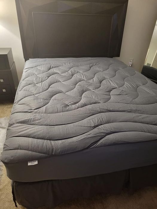 A photo shared by the reviewer showing the mattress topper on the bed