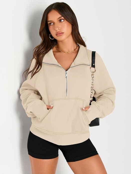 A model wearing a beige zip-up sweatshirt