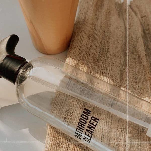 a clear spray bottle containing the bathroom cleaner