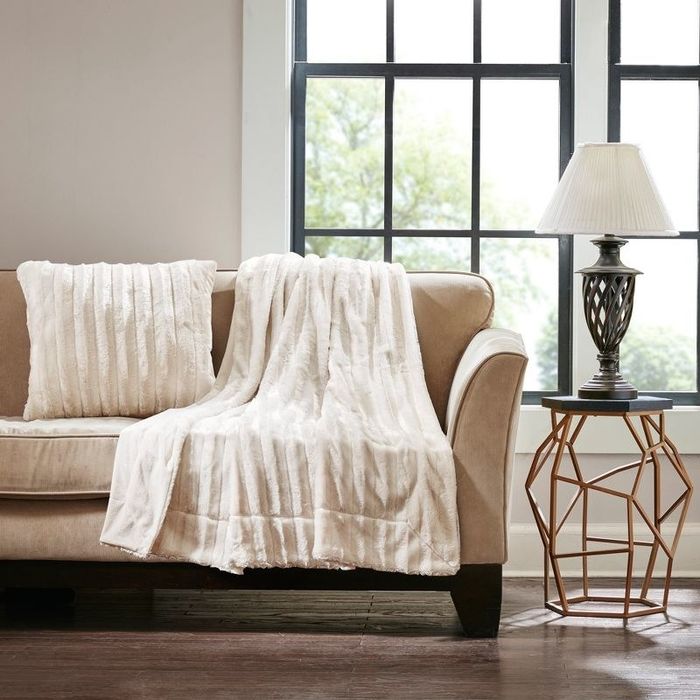 the ivory-colored throw draped on a couch