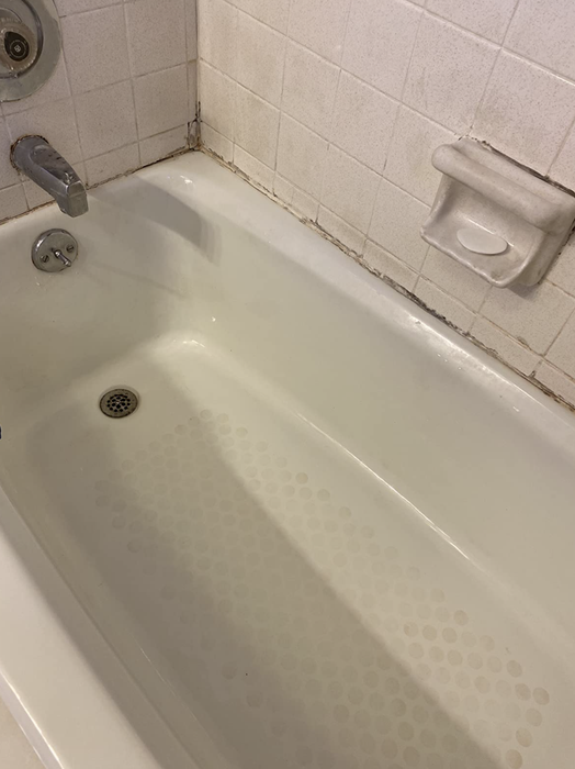 The same shower walls and bath floor look spotless after using the power scrubbing cleaning kit.