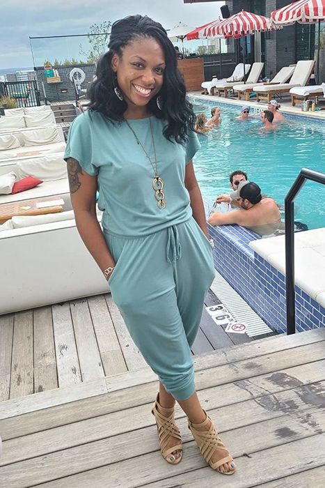 A reviewer showcasing the jumpsuit in Teal, paired with statement jewelry and chic sandals