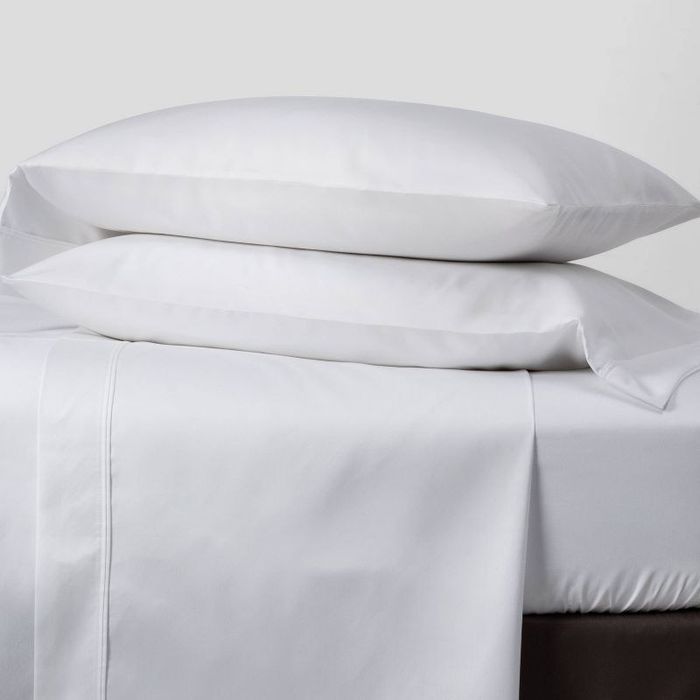 the sheet and pillowcase set neatly arranged on a made-up bed