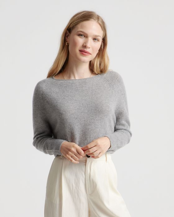 A person rocking a cozy sweater and light pants, striking a pose for a fashion photoshoot